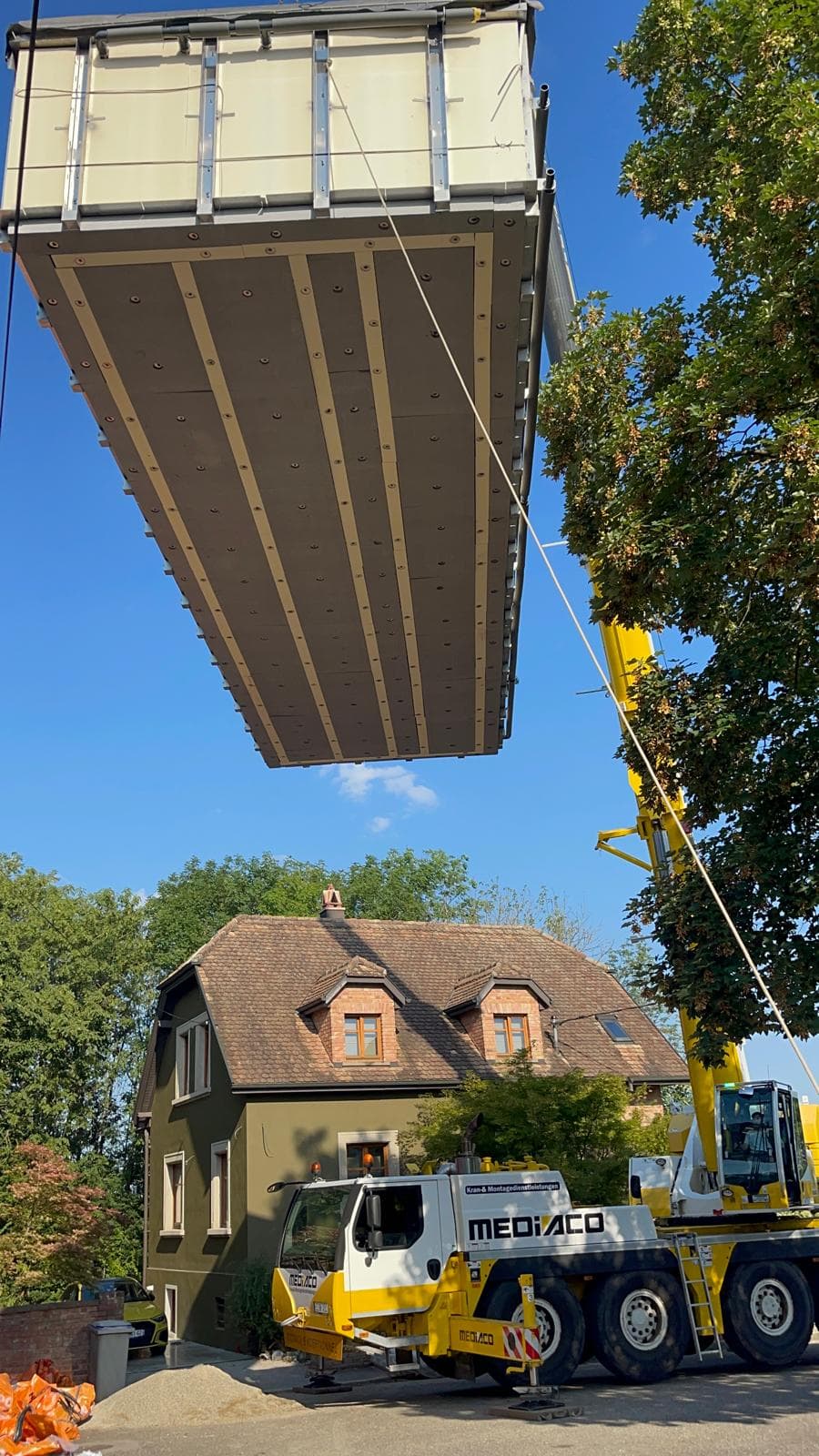 Chantier de piscine avec grue déposant une structure