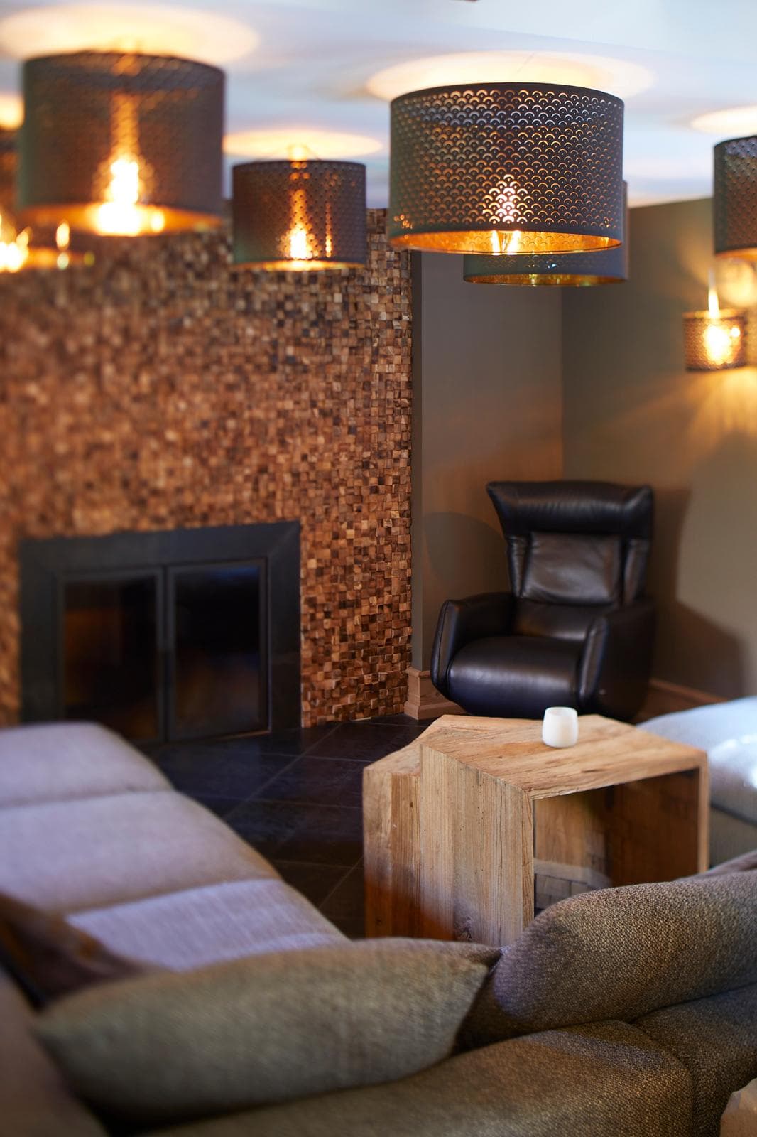 Lounge cosy avec mur en mosaïque bois et cheminée moderne